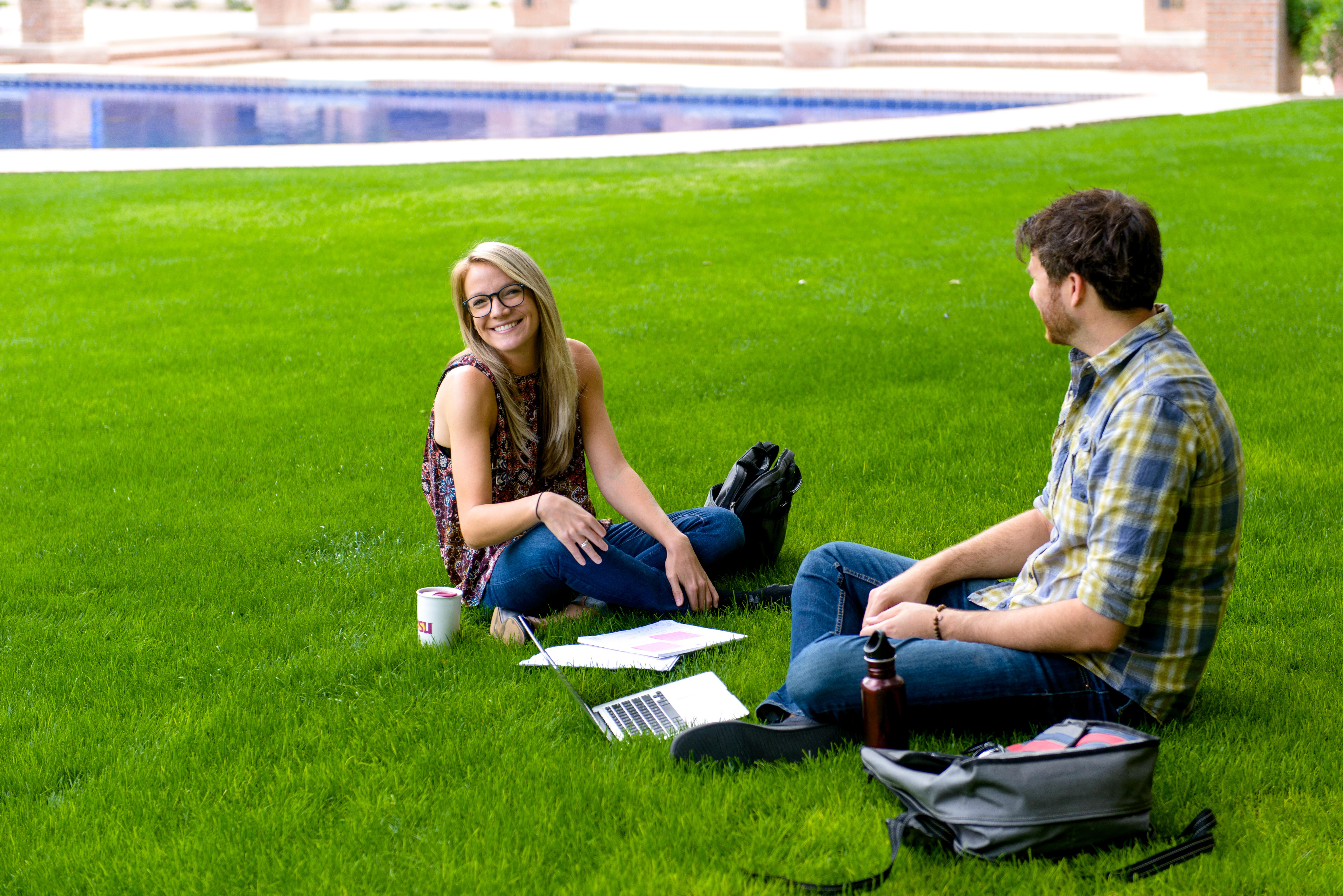 photo of 2 students studying on Fletcher lawn