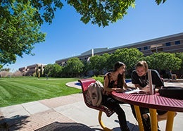 photo of students sitting at table on Fletcher lawn