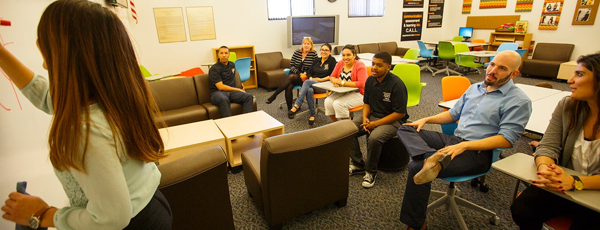 Students and faculty in front of a white board