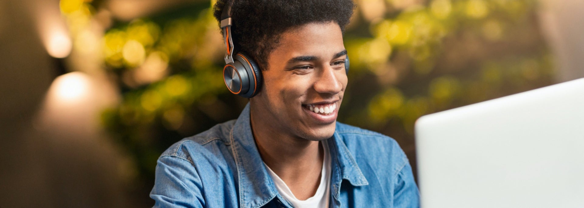 photo of student on computer with headphones