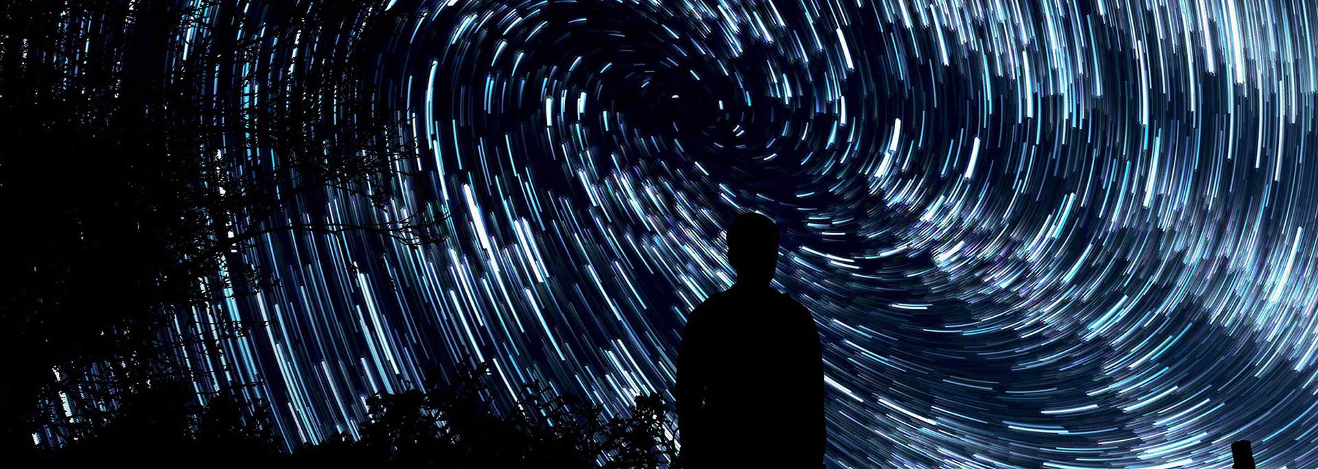 silhouette of a person standing against a starry sky
