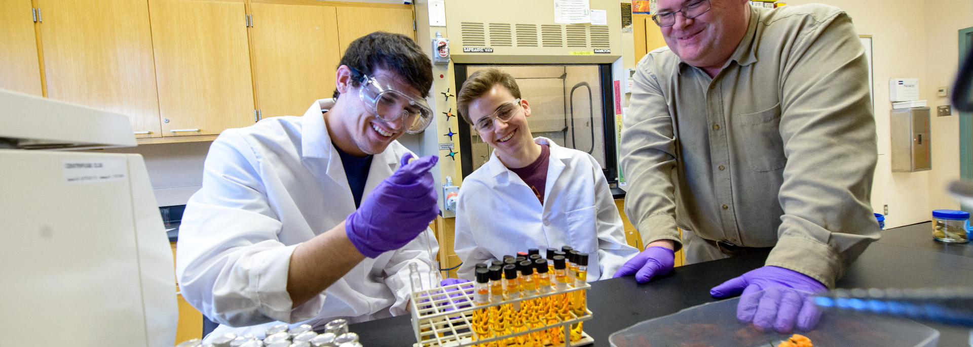 Professor working with two students in lab