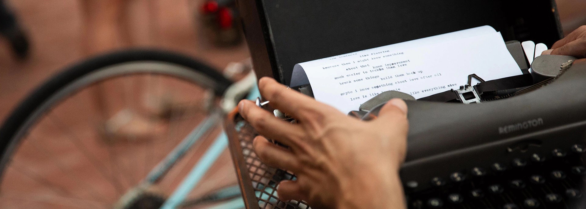 photo of student typing on a typewriter outside
