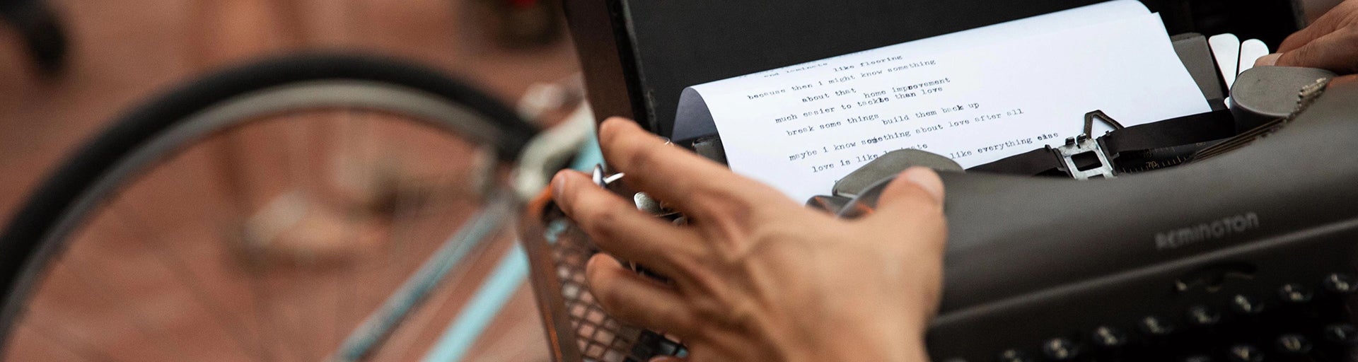 photo of student typing on a typewriter outside