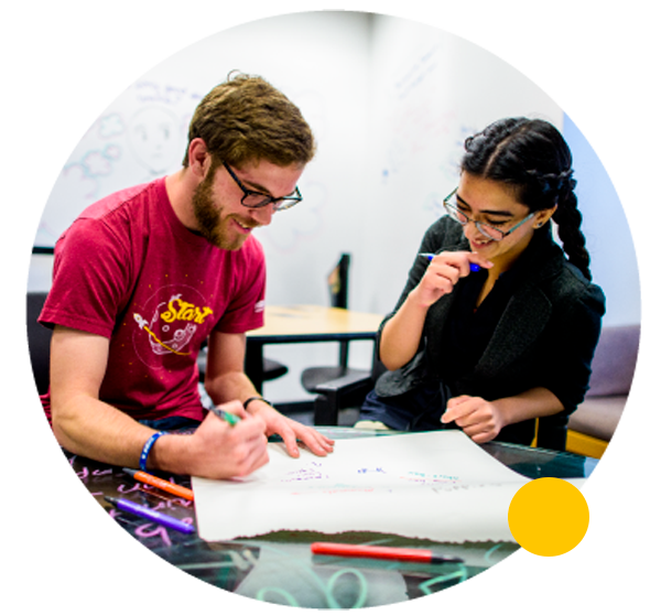 two students studying together in a classroom