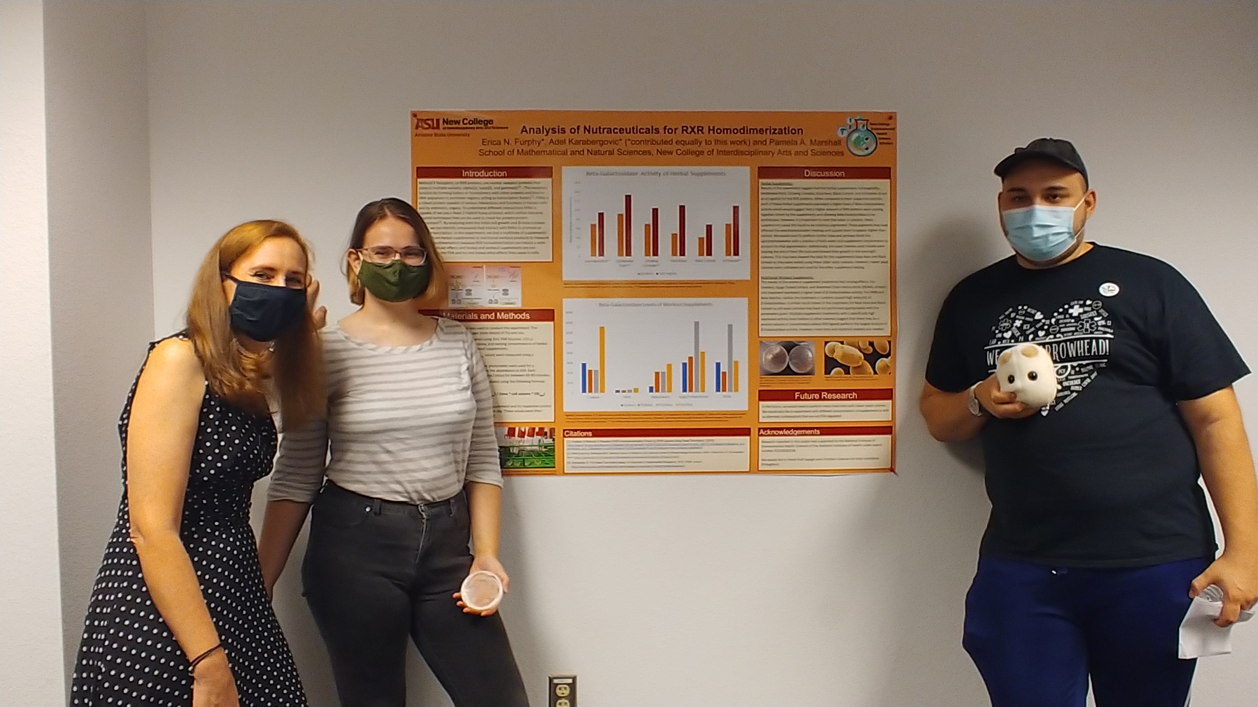 photo of 3 students standing by their research poster