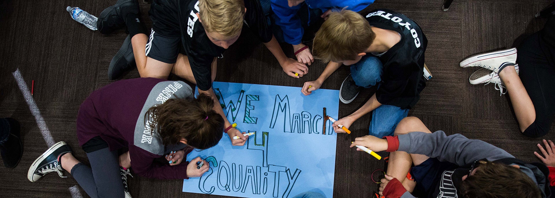 photo of students making a sign that reads 'equality for all'