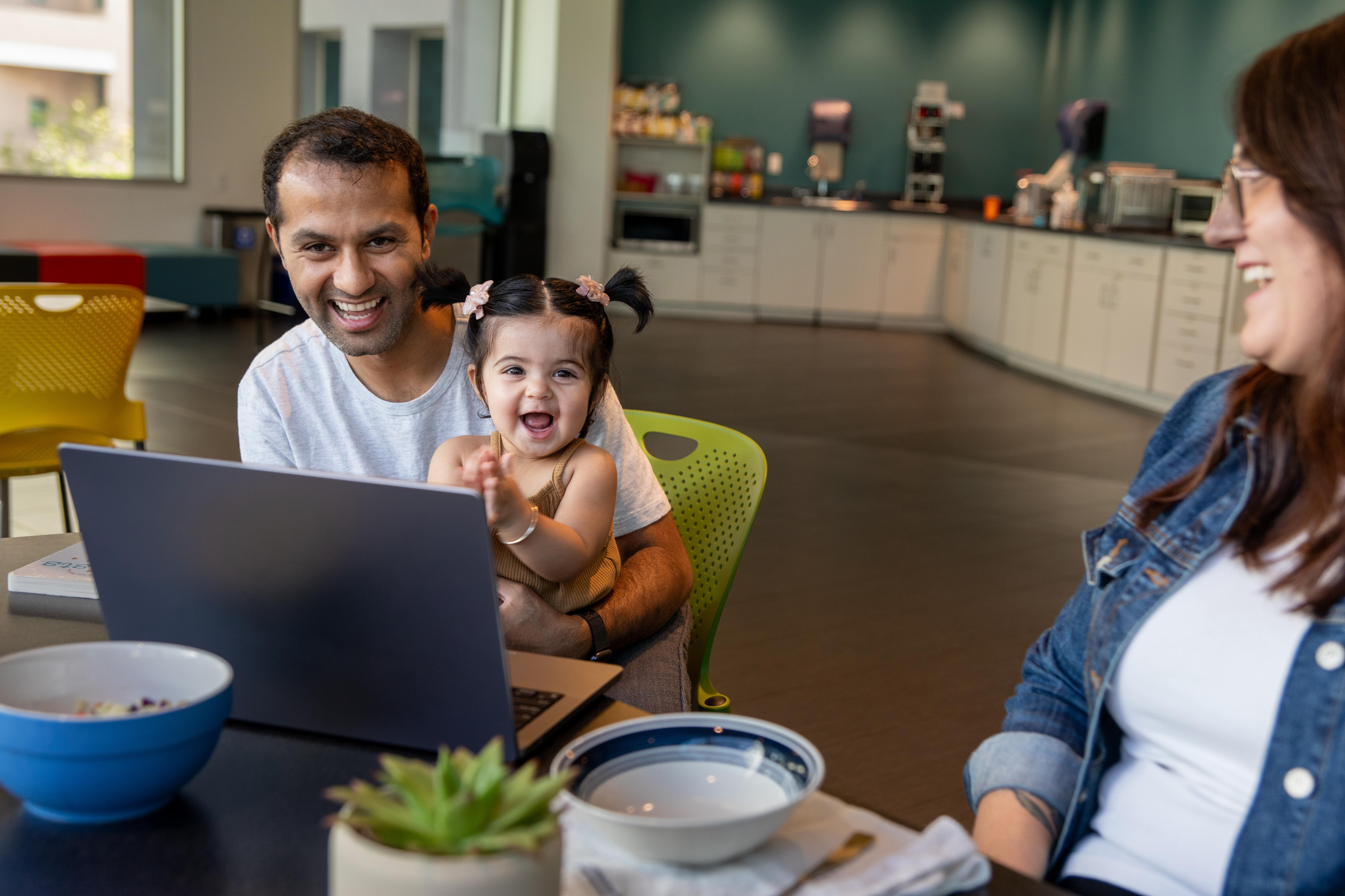 Family sitting in front of a computer in an office space