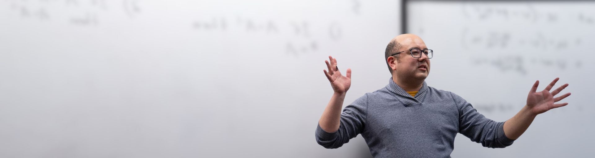 Joel Nishimura teaching in front of a whiteboard