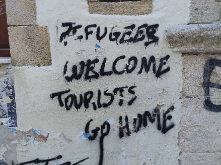 "Refugees welcome, tourists go home." Leftist political graffiti in the old town of Rethymno