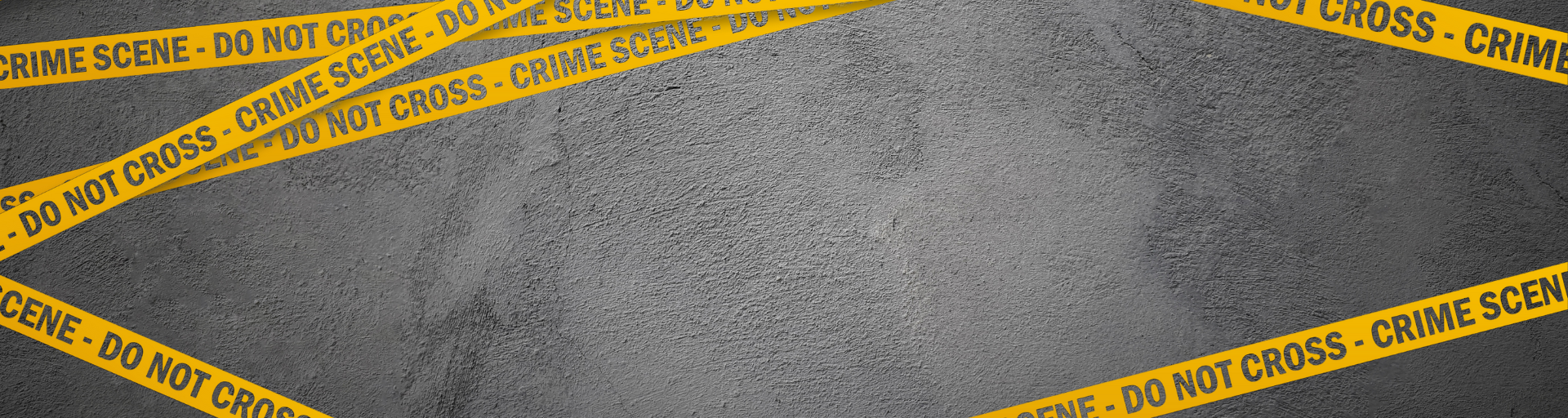 Gray concrete wall with diagonal yellow crime scene tape.