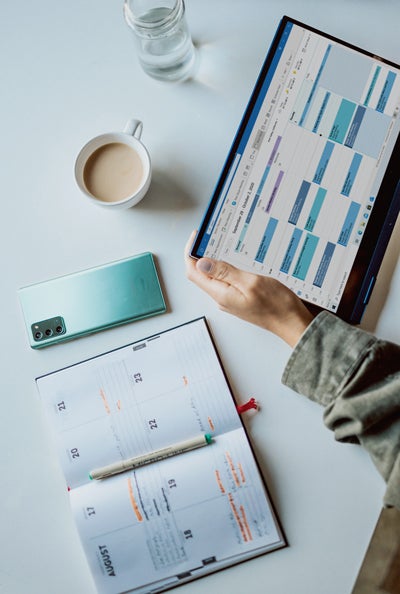 photo of computer calendar, cup of coffee and planner