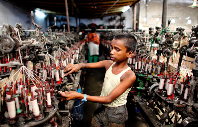 Image of a child performing forced labor at a textile factory