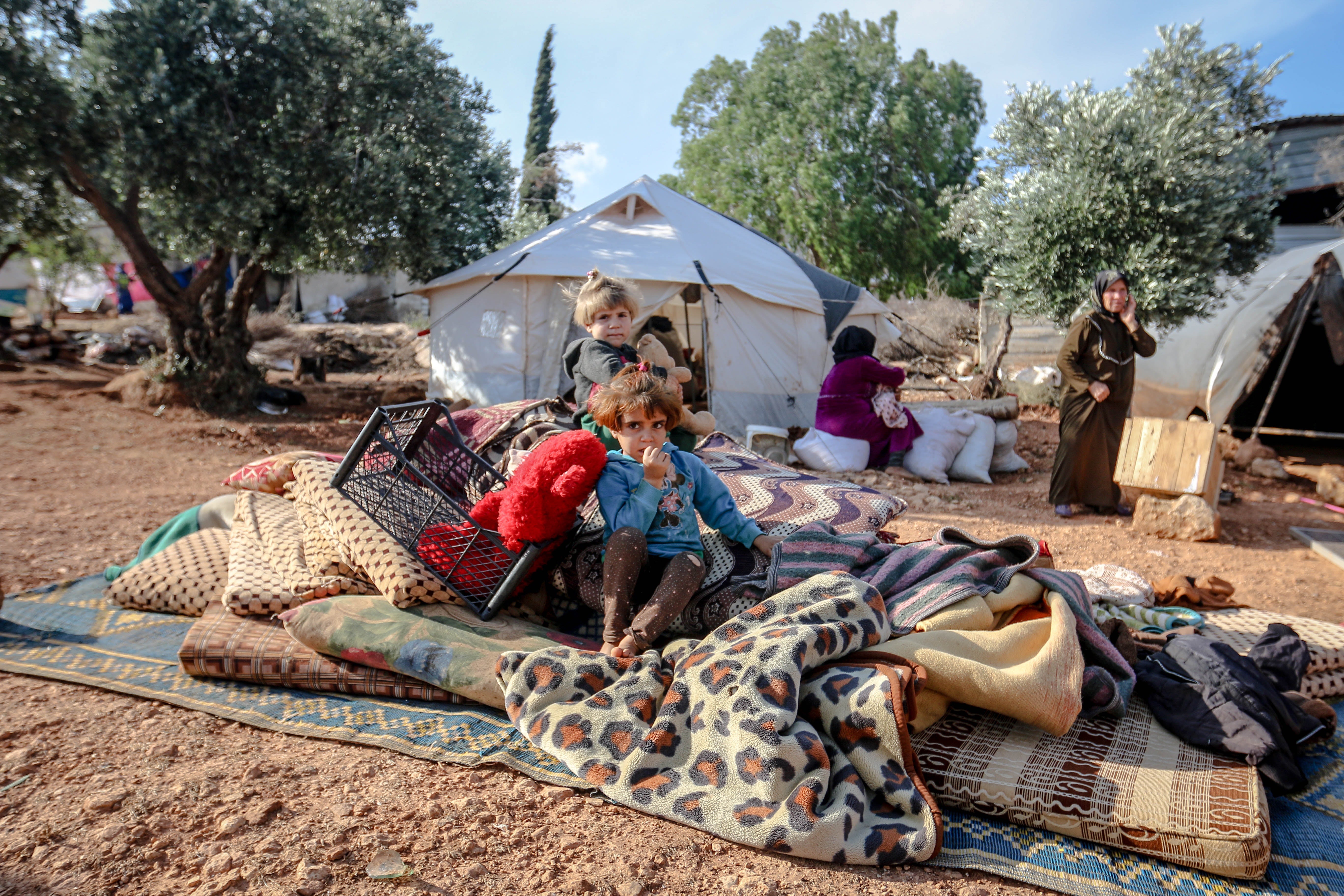 Children sitting in a refugee camp in Idlib, Idlib Governorate, Syria