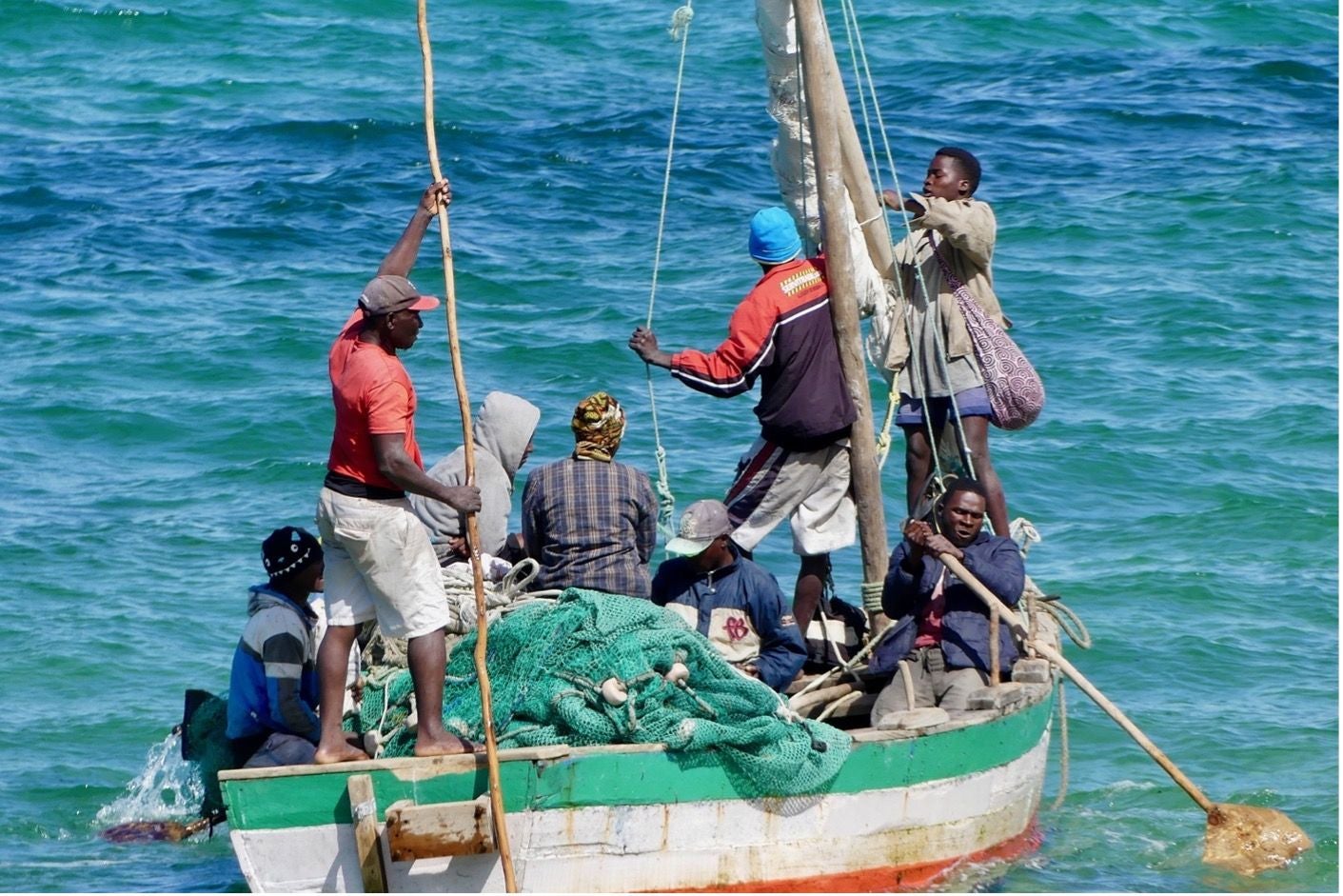 fishermen pulling in nets on a boat