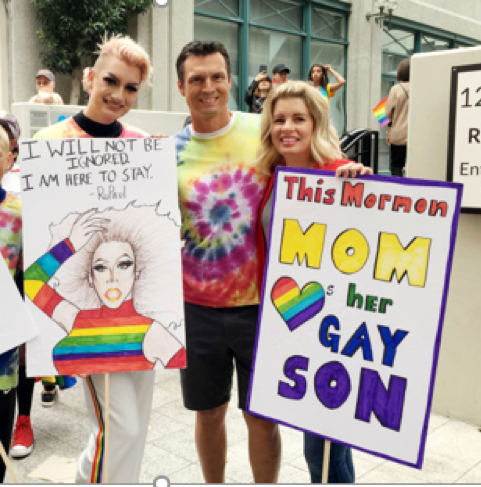 Mormon mother holds up a sign in support of her gay son