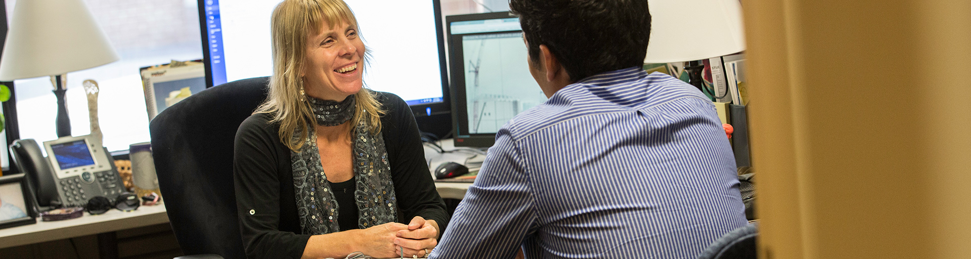 photo of Dr Majia Nadesan in office speaking with a student