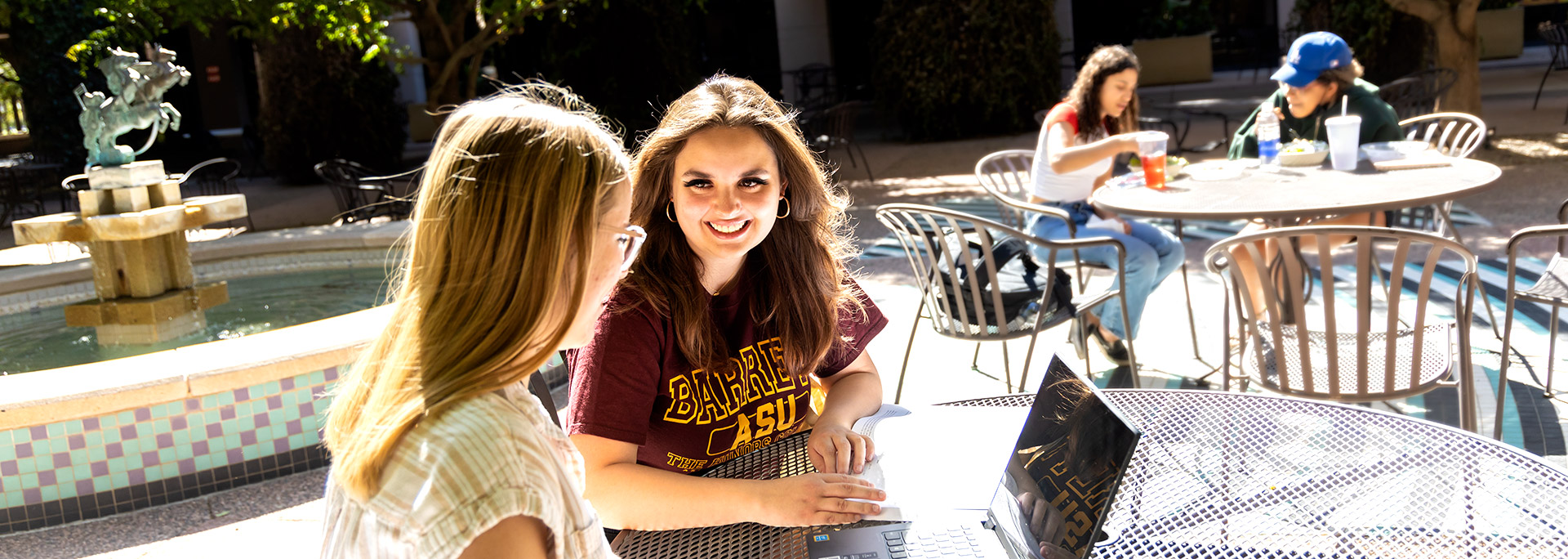 photo of 2 students sitting in the courtyard