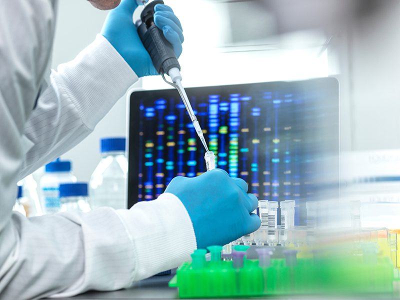 Researcher wearing gloves inserting dropper in tube
