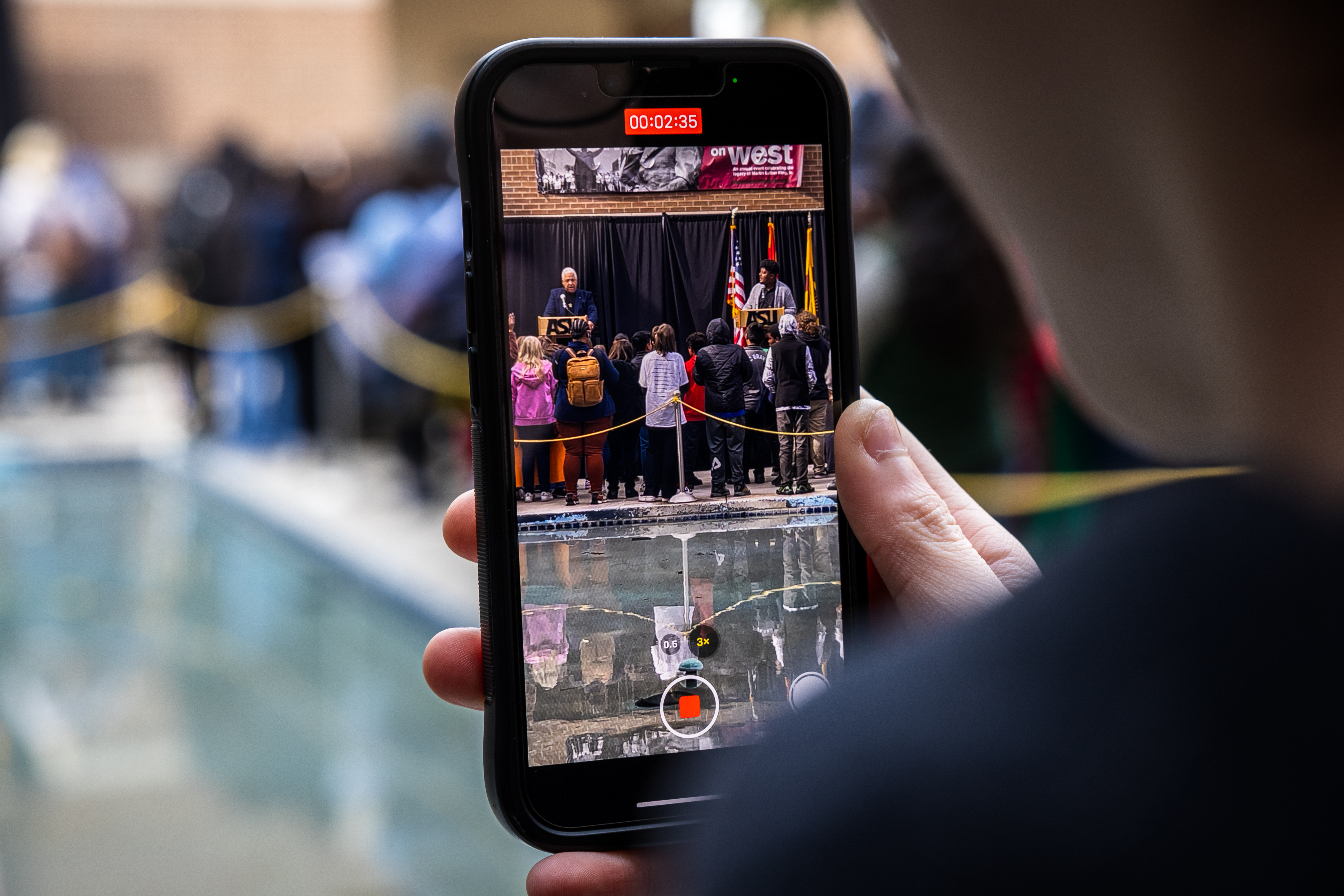 a person holding up an iphone recording an event