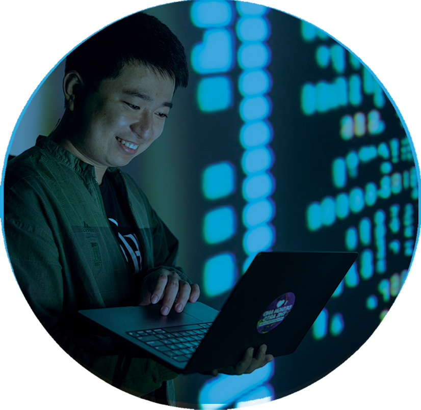 A student happily looking at a laptop