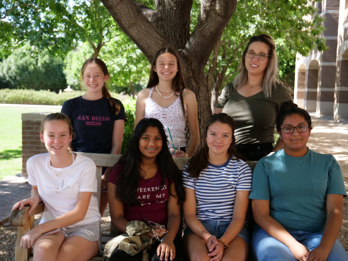 A group of young students smiling outside at the ASU West Valley campus